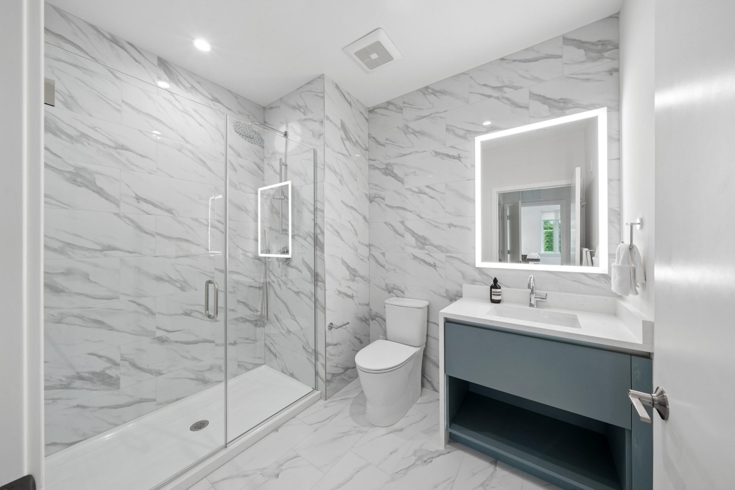 Bright marbled bathroom with enclosed shower area